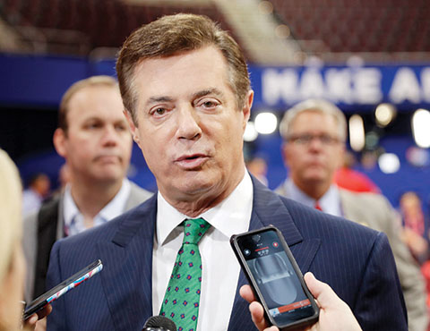 Trump Campaign Chairman Paul Manafort talks to reporters on the floor of the Republican National Convention at Quicken Loans Arena in Cleveland as Rick Gates listens at back left. Emails obtained by The Associated