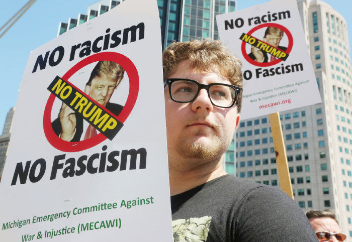 Mike Vultaggio of Warren is amongst the protesters voicing their opinion against Republican presidential candidate Donald Trump as he speaks inside at the Detroit Economic Club at the Cobo Center in downtown Detroit on Monday. — AP