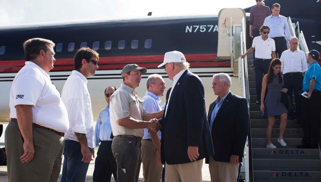 Republican presidential candidate Donald Trump followed by his running mate Indiana Gov. Mike Pence shakes hands with Louisiana Attorney General Jeff Landry as he is greeted by Louisiana officials upon his arrival at the Baton Rouge airport in Baton Ro