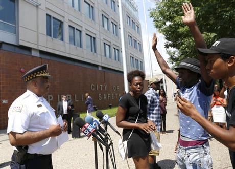 Chicago Police Superintendent Eddie Johnson left is blocked by three protestors as he tries to deliver a written statement about the recent release of police shooting video to television reporters outside the police department headquarters Friday Aug