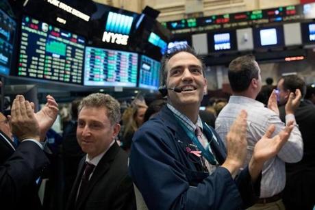 Traders applauded at the closing bell Thursday on the floor of the New York Stock Exchange