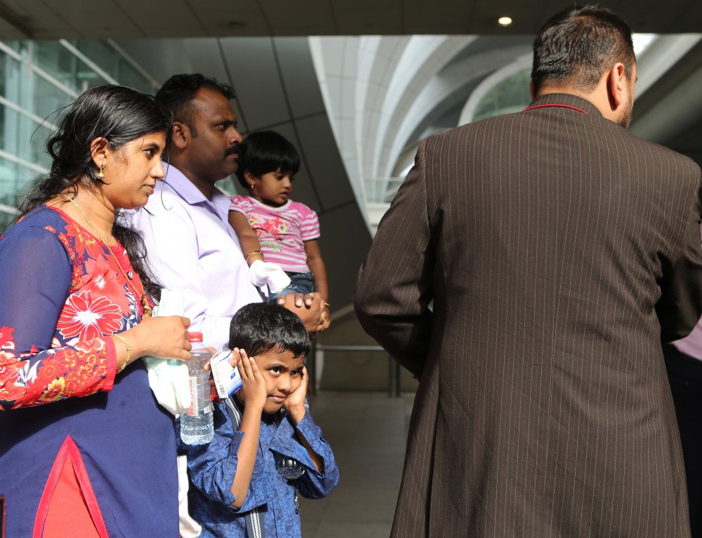 A family is helped to a taxi after safely evacuating a plane that crash-landed and caught fire Wednesday in Dubai halting all traffic at the Middle East's busiest airport