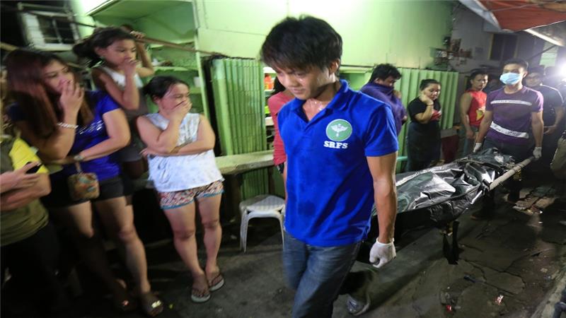 Filipino residents view a dead body of an alleged drug dealer killed during a police operation against illegal drugs in Manila Philippines 23 August 2016