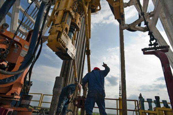 FOR BLOOMBERG NEWS ES_OILRIG_19-A floor hand signals to the driller to pull the pipe from the mouse hole on Orion Drilling Co.'s Perseus drilling rig. The Perseus is drilling for oil and gas in the Eagle Ford Shale in Webb County Te