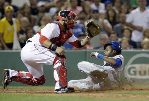 Kansas City Royals Lorenzo Cain right slides safely at home as Boston Red Sox's Sandy Leon left waits for the ball in the sixth inning of a baseball game Sunday Aug. 28 2016 in Boston