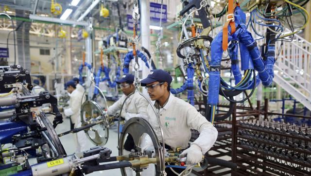 Employees work at the assembly line of a car manufacturing plant in Rajasthan