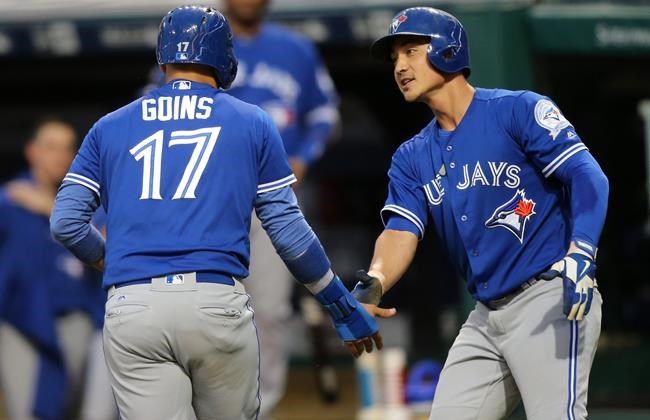 Toronto Blue Jays&#39 Ryan Goins is welcomed at home plate by Darwin Barney after they both scored on a single by Devon Travis during the second inning of a baseball game against the Cleveland Indians Saturday Aug. 20 2016 in Cleveland. (AP Phot