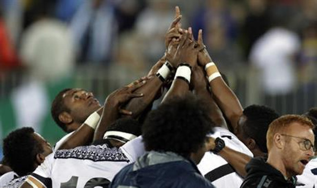 Fiji's players form a human ring after winning the men's rugby sevens gold medal match against Britain at the Summer Olympics in Rio de Janeiro Brazil Thursday Aug. 11 2016