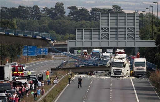 The scene on the London-bound M20 motorway about 30 miles southeast of the capital after a lorry hit a pedestrian bridge causing it to collapse Saturday Aug. 27 2016. Witnesses and emergency services say a truck has struck an overpass