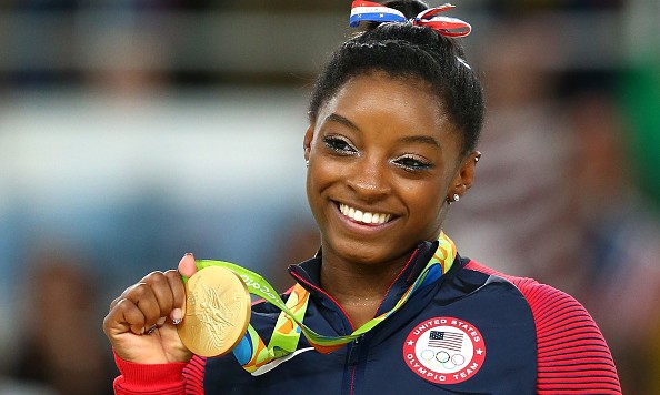 RIO DE JANEIRO BRAZIL- AUGUST 16 Gold medalist Simone Biles of the United States celebrates on the podium at the medal ceremony for the Women's Floor on Day 11 of the Rio 2016 Olympic Games at the Rio Olympic Arena