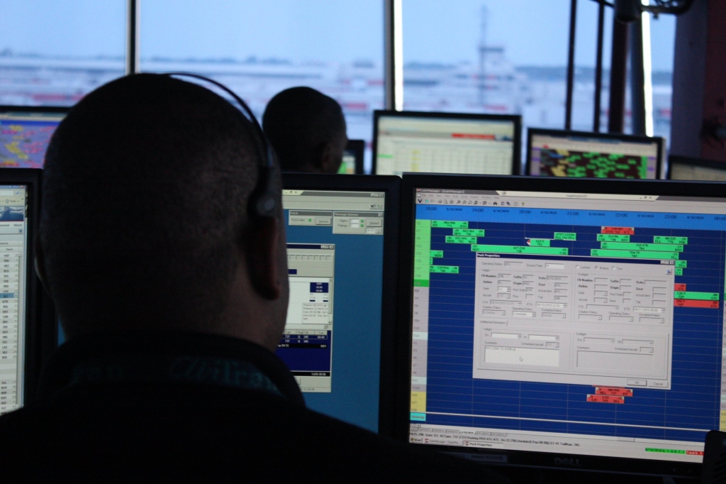 An air traffic controller sits behind a computer screen at the Hartsfield Jackson Atlanta International Airport