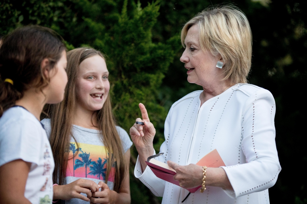 Campaign 2016 Clinton-2 Democratic presidential nominee Hillary Clinton speaks with neighborhood children as she signs a book for them following a fundraiser at a private home in Sagaponack N.Y. on Tuesday