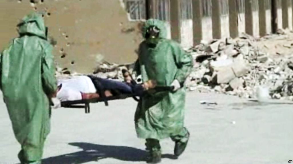 FILE- People in protective suits and gas masks conducting a drill on how to treat casualties of a chemical weapons attack in Aleppo Syria