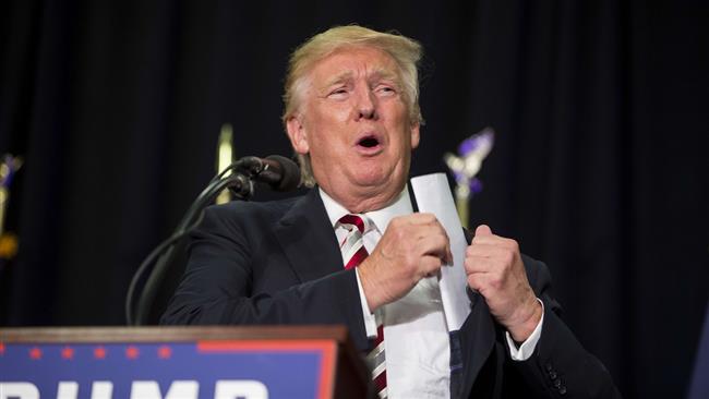 Republican presidential candidate Donald Trump takes a paper out of his jacket during his rally at Windham High School