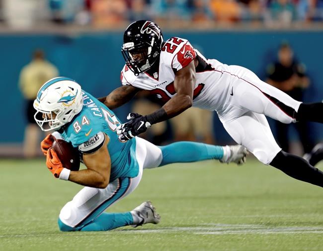 Miami Dolphins tight end Jordan Cameron is brought down by Atlanta Falcons strong safety Keanu Neal after a reception during the first half of an NFL preseason football game in Orlando Fla. Thursday Aug. 25 2016.(AP