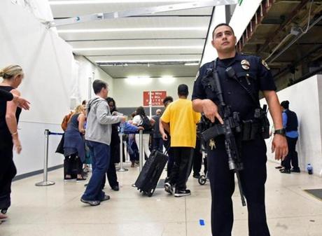 Delayed passengers inside Terminal 7 at Los Angeles International Airport line up to go through TSA security check following a false alarm Sunday night