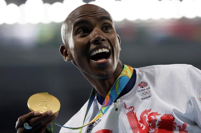 Britain's Mo Farah celebrates with the gold medal after the men's 10,000-meter final during the athletics competitions of the 2016 Summer Olympics at the Olympic stadium in Rio de Janeiro Brazil Saturday Aug. 13 2016. (AP