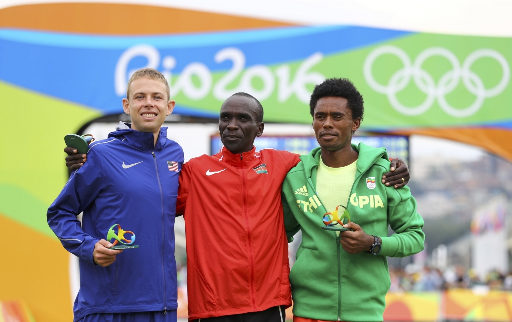 Feyisa Lilesa of Ethiopia Eliud Kipchoge of Kenya and Galen Rupp of the US attend flower ceremony for the men’s marathon in Rio Sunday. — Reuters