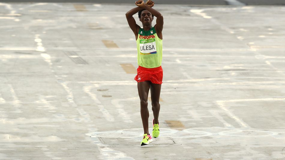 Feyisa Lilesa of Ethiopia celebrates crosses the line to win silver during the men's marathon