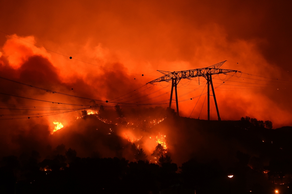 Fierce wind-fanned flames threaten hilltop power lines near the festival commune of Les Pennes-Mirabeau north of Marseilles Getty Images