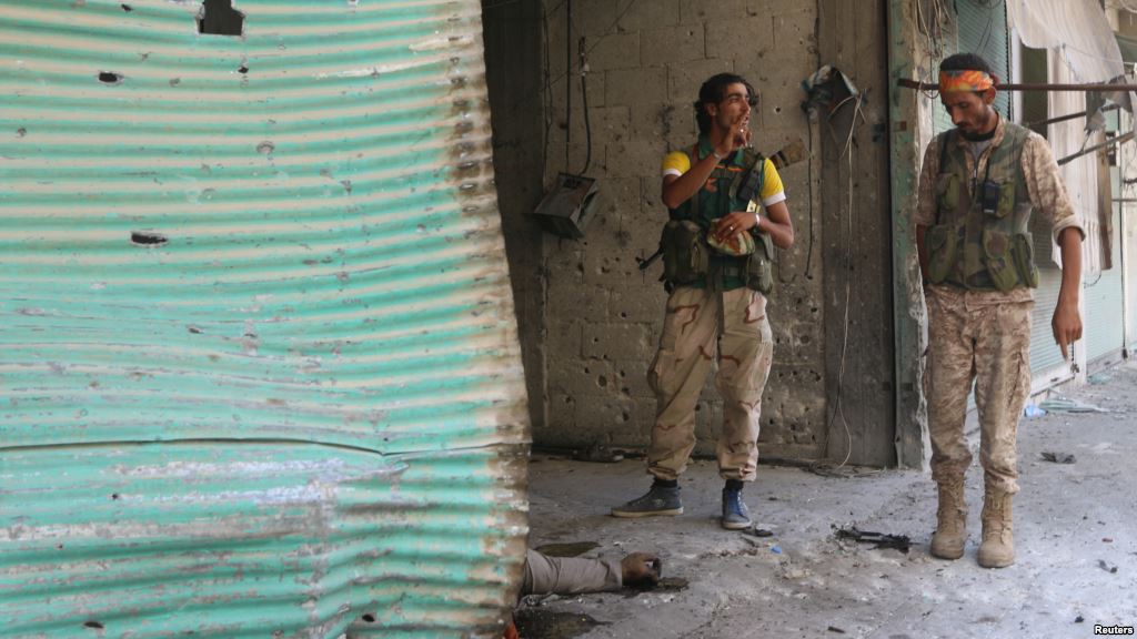 Rebel fighters ride a tank in an artillery academy of Aleppo Syria