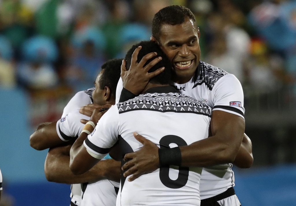 Leone Nakarawa hugs a teammate after winning after Fiji won the gold medal match against Britain in the mens rugby sevens at the 2016 Summer Olympics in Rio de Janeiro Brazil Thursday Aug. 11 2016