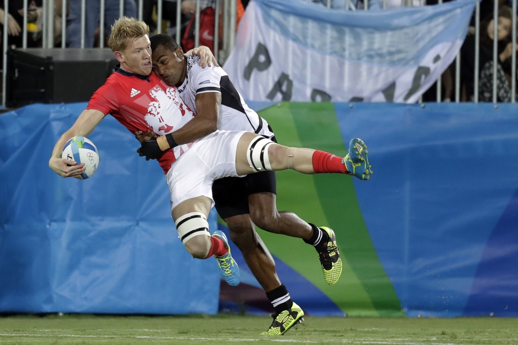 Britain's Sam Cross left is tackled by Fiji's Apisai Domolailai during the men's rugby sevens gold medal match at the Summer Olympics in Rio de Janeiro Brazil Thursday Aug. 11 2016