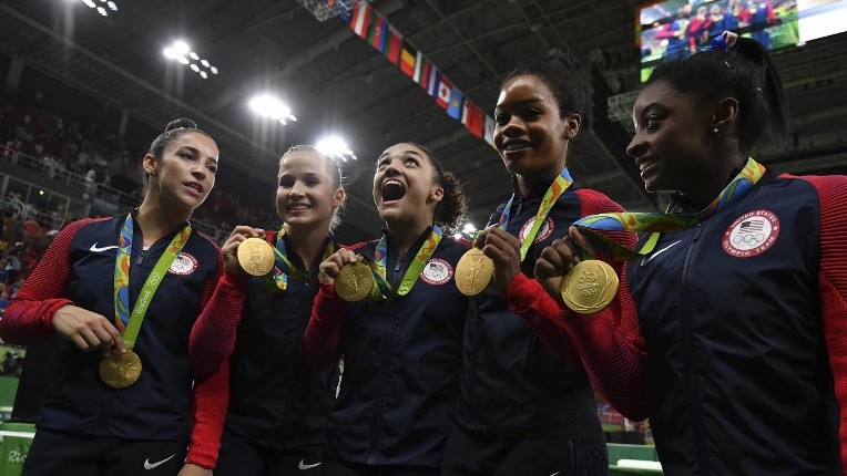 US gymnasts Alexandra Raisman Madison Kocian Lauren Hernandez Gabrielle Douglas and Simone Biles celebrate with their medals on the podium during the women's team final Artistic Gymnastics at the 2016 Olympic Games in Rio de J