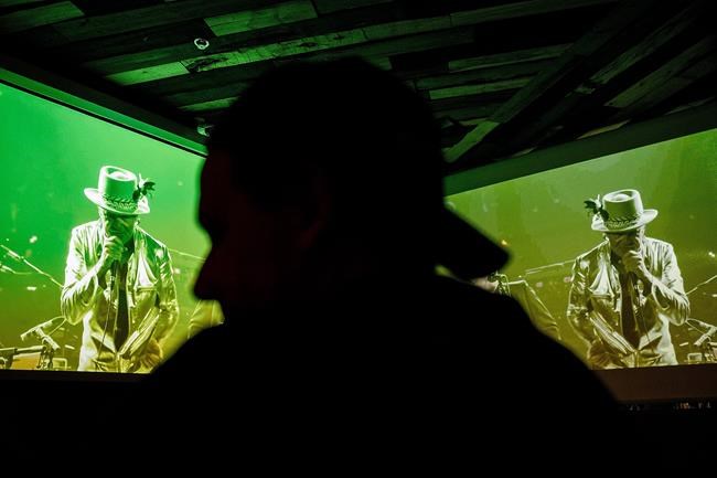 A fan is silhouetted against screens during the broadcast of the Tragically Hip's final concert at the Rocky Mountain Ice House in Edmonton Alta. on Saturday Aug. 20 2016. THE CANADIAN PRESS  Codie McLachlan