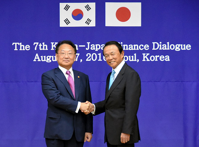 Finance Minister Taro Aso right shakes hands with his South Korean counterpart Yoo Il-ho in Seoul on Aug. 27