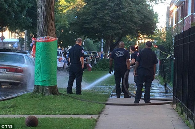 Fire Department personnel wash down the scene after a fatal shooting in the 7000 block of South Artesian Avenue on Aug. 21 2016