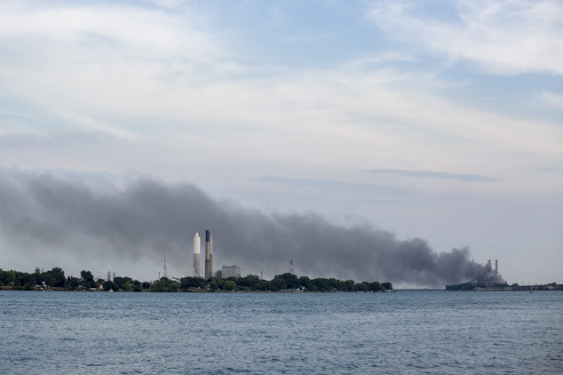 Smoke rises above the St. Clair River as a large fire burns inside the DTE Energy St. Clair Power Plant Thursday Aug. 11 2016 in East China Township Mich