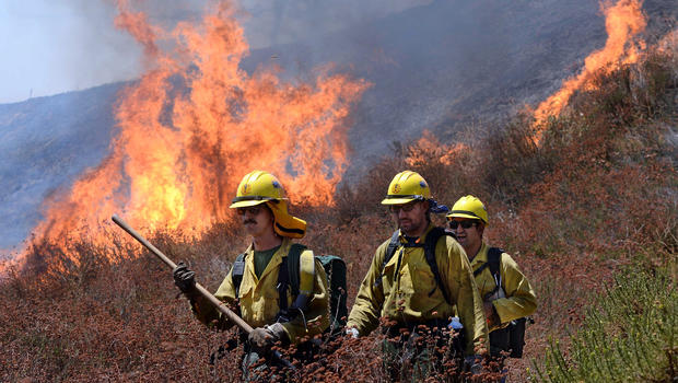 Firefighters battle the Bluecut Fire along Swarthout Canyon Road in the Cajon Pass north of San Bernardino Calif. Tuesday Aug. 16 2016