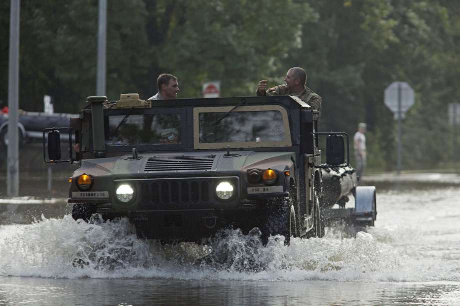 Army National Guard vehicles splash through floodwaters near Tickfaw La