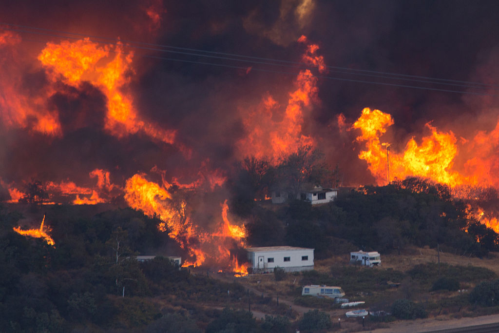 Flames sweep through a rural community at the Blue Cut Fire