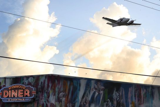 A plane sprays pesticide over the Wynwood neighborhood in the hope of controlling and reducing the number of mosquitoes some of which may be capable of spreading the Zika virus