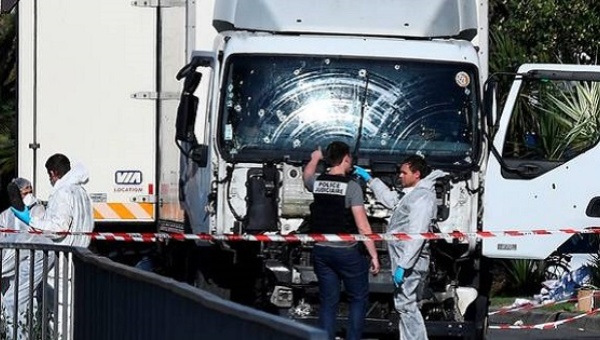 Forensics officers and policemen look for evidence near a truck on the Promenade des Anglais seafront Nice