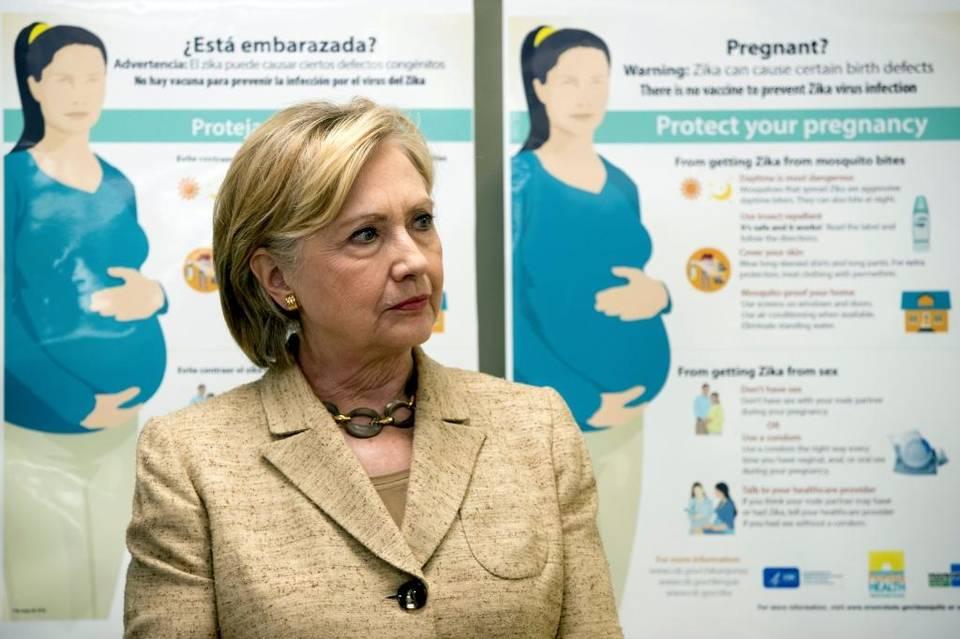 Informational Zika posters for pregnant woman are displayed behind Democratic presidential candidate Hillary Clinton as she takes a tour of Borinquen Health Care Center in Miami on Tuesday