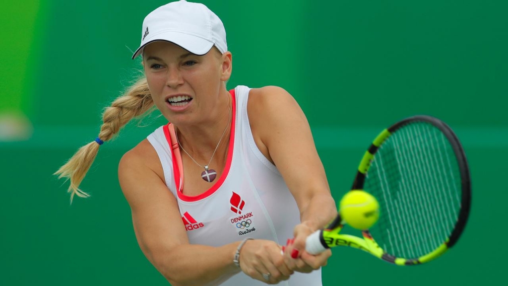 Four-time champ Caroline Wozniacki has been beaten in the first round of the WTA Connecticut Open