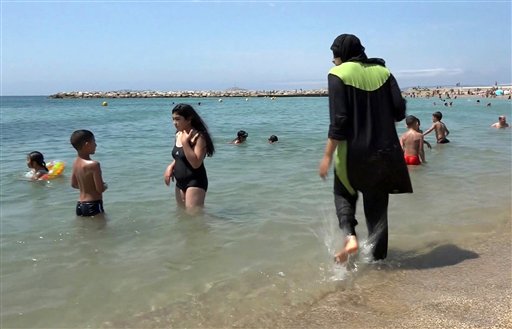 Nissrine Samali 20 gets into the sea wearing a burkini a wetsuit-like garment that also covers the head in Marseille southern France. Burkinis vs. bikinis. Beneath the clash