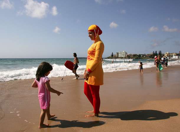 Lifeguard wearing burqini talks to a young girl