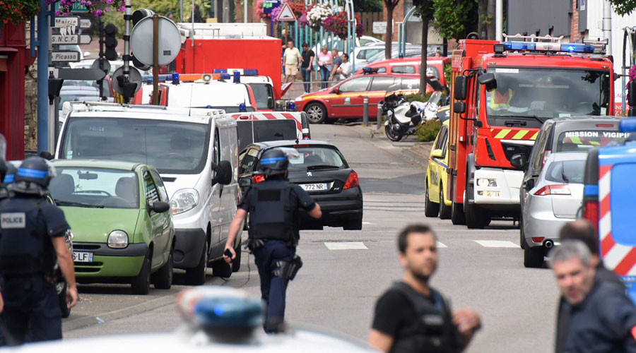 Police and rescue workers stand at the scene after two assailants had taken five people hostage in the church at Saint Etienne-du-Rouvray near Rouen in Normandy France