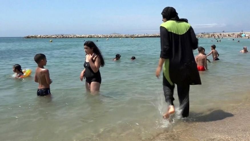 En esta imagen de archivo tomada el 4 de agosto de 2016 tomada de un video Nissrine Samali de 20 años se mete en el agua vistiendo un burkini un traje de baño completo que cubre de pies a cabeza en Marsella en el sur de Francia. (AP