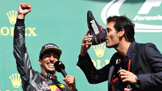 Mark Webber drinks champagne from the boot of Daniel Ricciardo of Australia on the podium of the Belgium Grand Prix