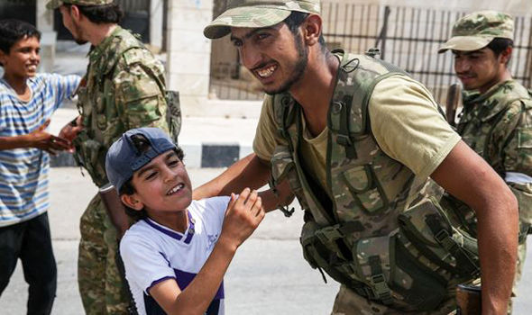 GETTYChildren fling their arms around Turkish solders who freed their town from the clutches of ISIS