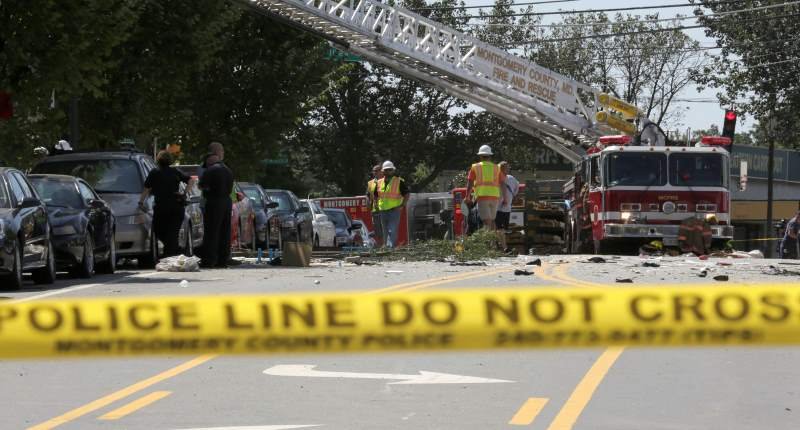 Fire fighters look through the debris of a four-story building that was destroyed in an explosion that has left up to seven people missing in Silver Spring Maryland on Aug. 11 2016