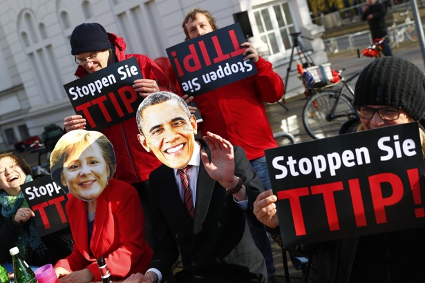 Protesters wear masks of U.S. President Barack Obama and German Chancellor Angela Merkel as they demonstrate against the TTIP in Hanover in April