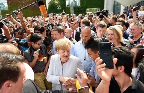 German Chancellor Angela Merkel left smiles during