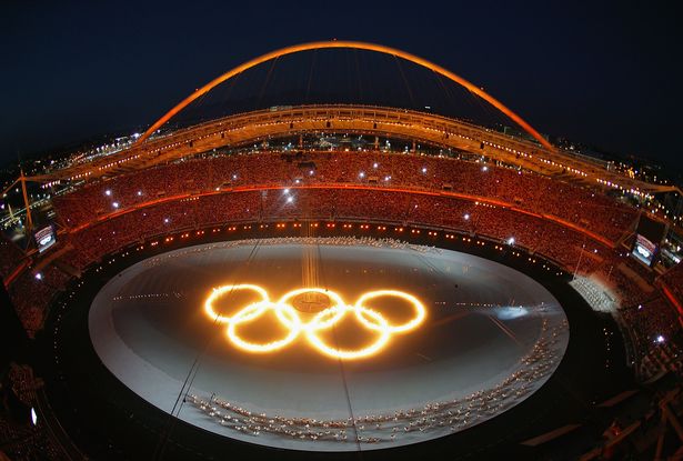 The Olympic rings are seen as drummers perform during the opening ceremony of the Athens 2004 Summer Olympic Games