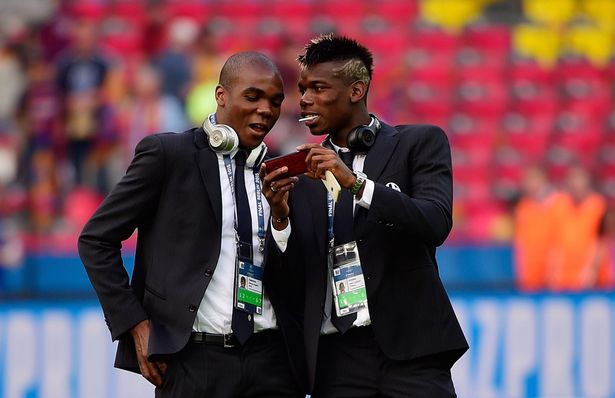 Juventus&#039 Angelo Ogbonna and Paul Pogba stand on the pitch after arriving at the stadium